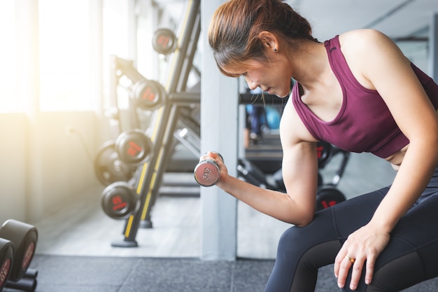 Sprawności fizycznej Azjatyckiej dziewczyny podnośny dumbbell przy gym.