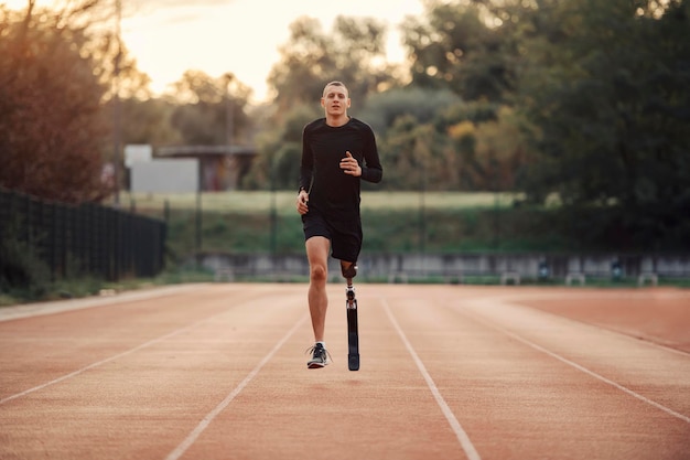 Sprawny sportowiec ze sztuczną nogą biegający na stadionie