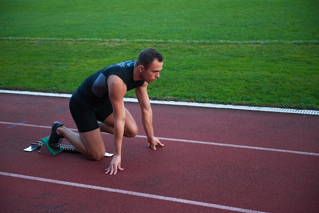 Sprinter zostawiający bloki startowe na bieżni. Wybuchowy początek.