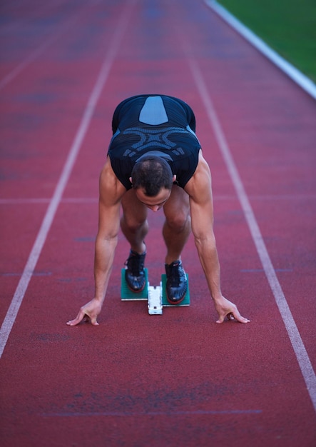 Sprinter zostawiający bloki startowe na bieżni. Wybuchowy początek.