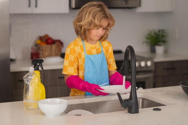 Sprzątanie domu dziecko chłopiec mycie naczyń w zlewie, detergenty i akcesoria do czyszczenia