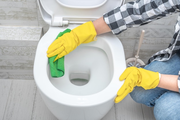 Sprzątanie wc Gospodyni sprzątająca mężczyzna w toalecie Odświeżenie toalety do czyszczenia muszli klozetowej do czyszczenia czystości i higieny Koncepcja usługi sprzątania