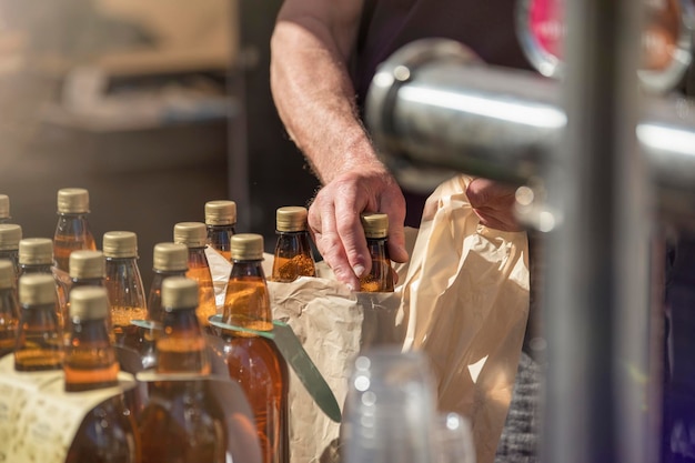 Sprzedawca piwa rzemieślniczego pakujący butelki piwa dla klienta koncepcja małego przedsiębiorstwa dla producenta