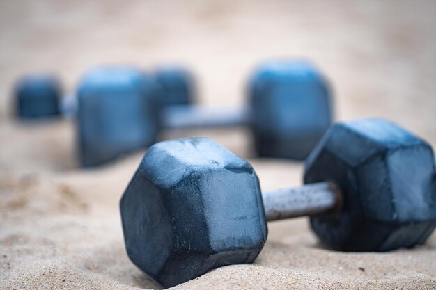 Sprzęt sportowy Dumbbells tło Dumbbell na plaży dla letnich sportów Dumbbell w piasku Trening z dumbbells w siłowni publicznej Zdrowy styl życia tło Sport baner z dumbbellami