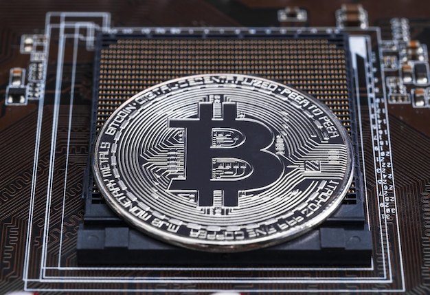 Srebrne monety bitcoin kryptowalut na płytce drukowanej