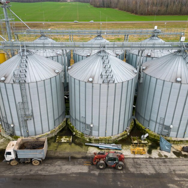 Srebrne silosy na agrozakładzie produkcyjnym do przetwórstwa suszenie czyszczenie i przechowywanie produktów rolnych mąka zboża i zboże Latanie dronem nad żelaznymi beczkami z ziarnem quadcopter photo