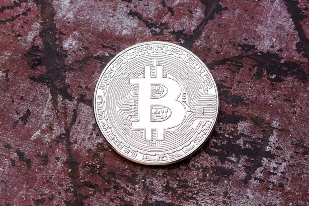 Srebrny bitcoin na czerwonym tle z bliska Zdjęcie w wysokiej rozdzielczości