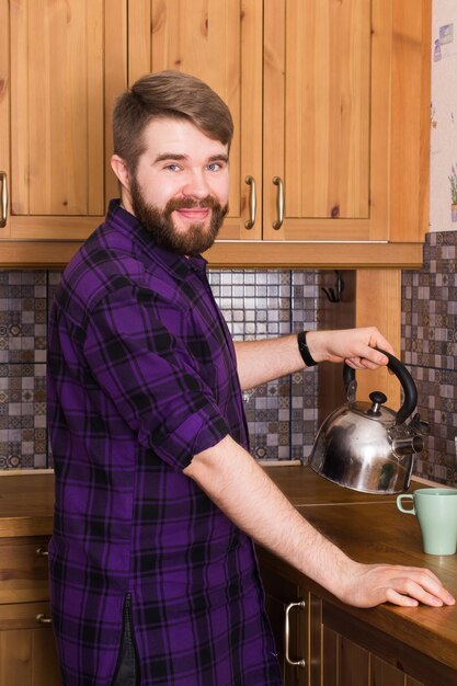 Zdjęcie Średni dorosły mężczyzna stoi w kuchni w domu