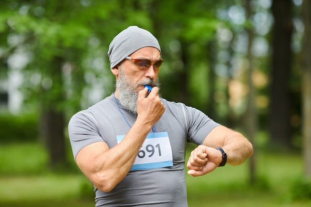 Średni Portret Profesjonalnego Trenera Sportowego Rozpoczynającego Trening Maratoński Z Gwizdkiem