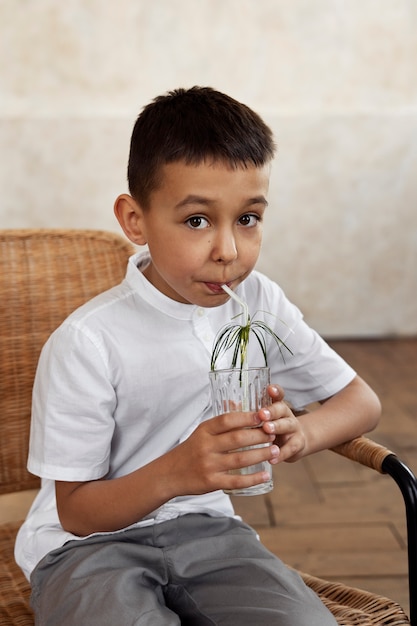 Zdjęcie Średni strzał dzieciak trzymający szklankę