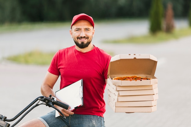 Zdjęcie Średni strzał facet trzyma pudełka po pizzy i schowka