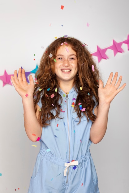 Zdjęcie Średni strzał szczęśliwa dziewczyna z konfetti