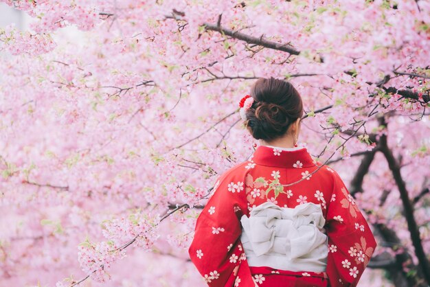 Zdjęcie Średnio dorosła kobieta w kimono w parku wiosną