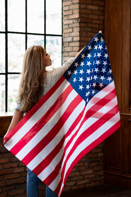 Średnio strzał kobieta trzyma amerykańską flagę