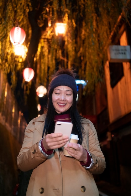 Zdjęcie Średnio strzał uśmiechnięta dziewczyna trzymająca smartfon