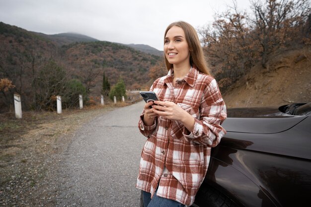 Zdjęcie Średnio strzał uśmiechnięta kobieta trzyma smartfon