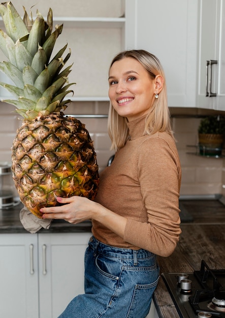 Średnio strzałowa kobieta z gigantycznym ananasem
