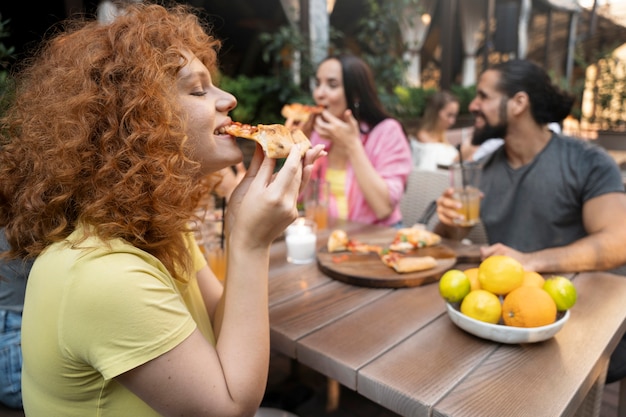 Zdjęcie Średnio strzałowi przyjaciele jedzący pizzę?