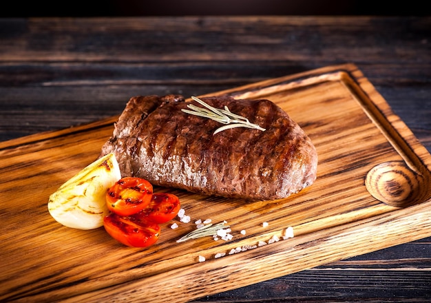 Średnio wysmażony grillowany stek Ribeye na drewnianej desce