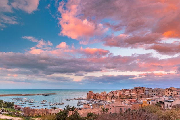 Średniowieczna twierdza w Cala Marina, port w nadmorskim mieście Castellammare del Golfo o zachodzie słońca, Sycylia, Włochy