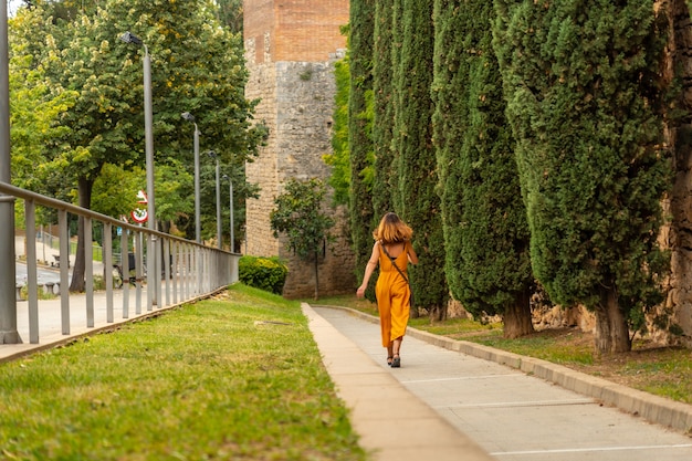 Średniowieczne miasto Girona, młody turysta spacerujący wzdłuż muru, Costa Brava w Katalonii na Morzu Śródziemnym. Hiszpania