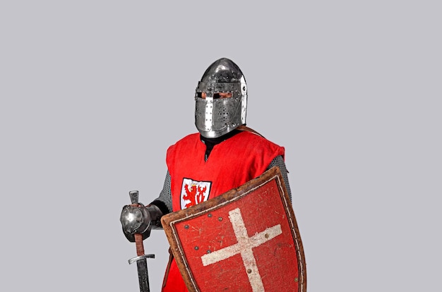 Średniowieczny rycerz w hełmie, zbroi, z tarczą w dłoniach