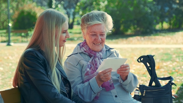 Zdjęcie Środka zamknięty stara kobieta czyta list ładna młoda kobieta w parku up