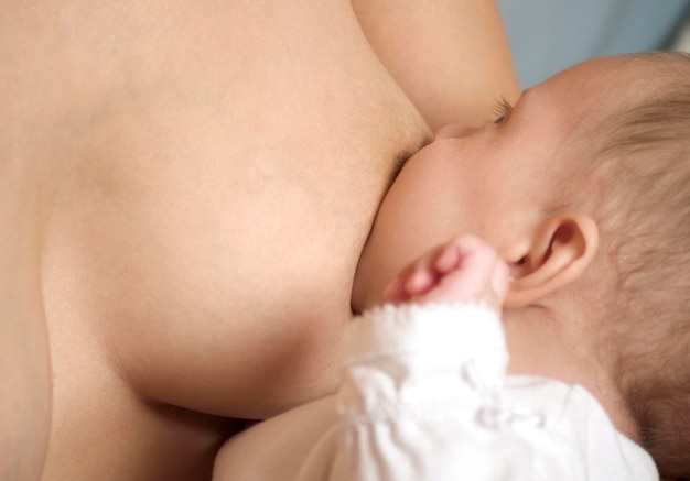 Zdjęcie Środkowa część karmiącej piersi matki dziewczynki