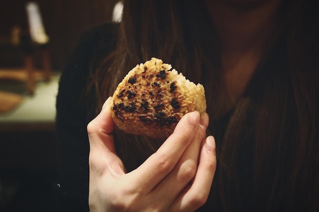Środkowa część kobiety trzymającej onigiri