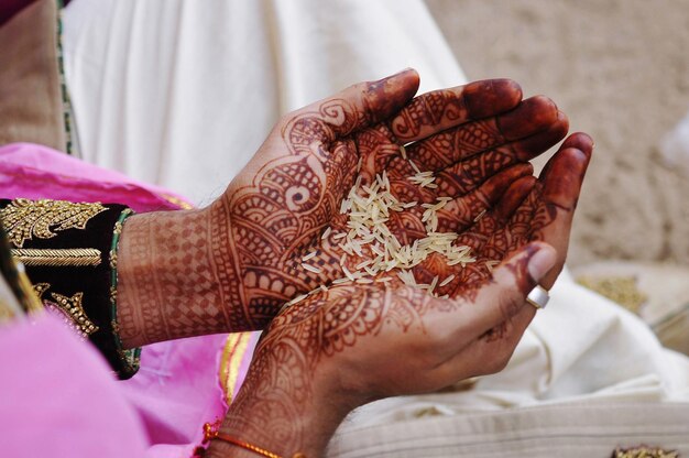 Zdjęcie Środkowa część kobiety trzymającej ryż w dłoni