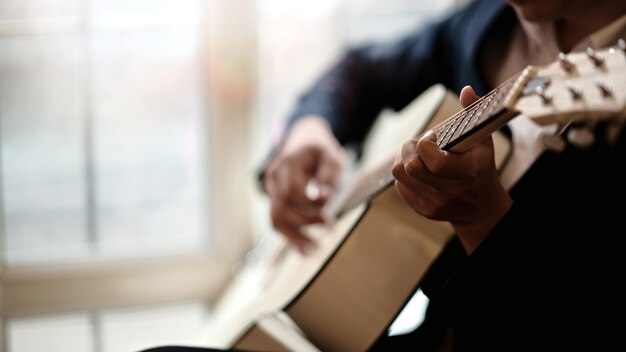 Zdjęcie Środkowa część mężczyzny grającego na gitarze