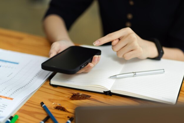 Środkowa część mężczyzny używającego telefonu komórkowego podczas pracy na stole