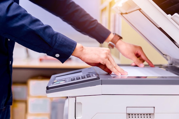 Zdjęcie Środkowa sekcja biznesmena używającego kserokopiarki w biurze