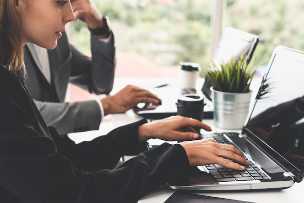 Środkowa sekcja bizneswoman używająca laptopa na biurku w biurze