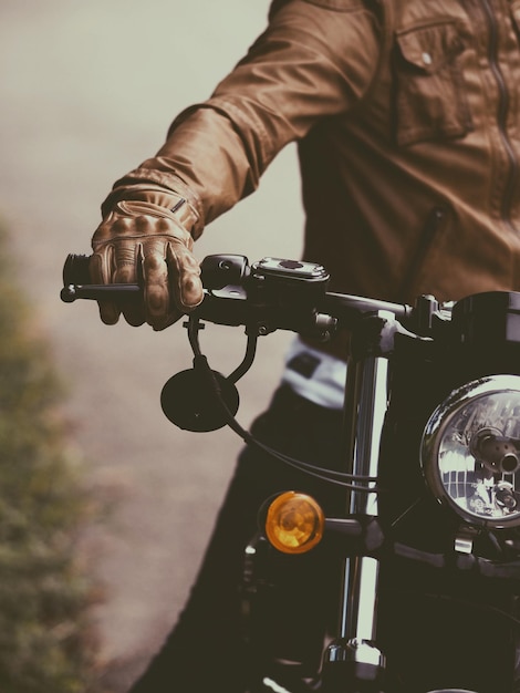 Zdjęcie Środkowa sekcja człowieka jeżdżącego na motocyklu po drodze