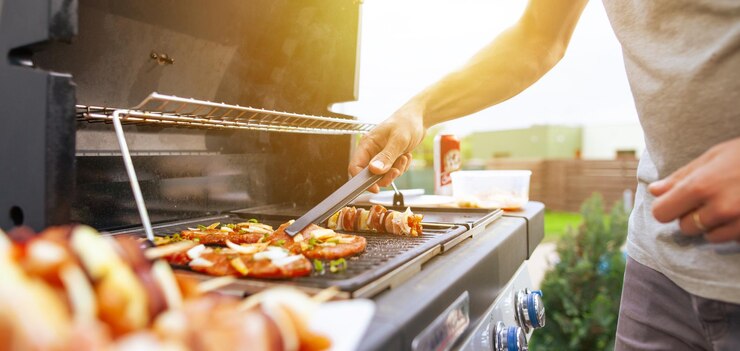 Zdjęcie środkowa sekcja człowieka przygotowującego jedzenie na grillu
