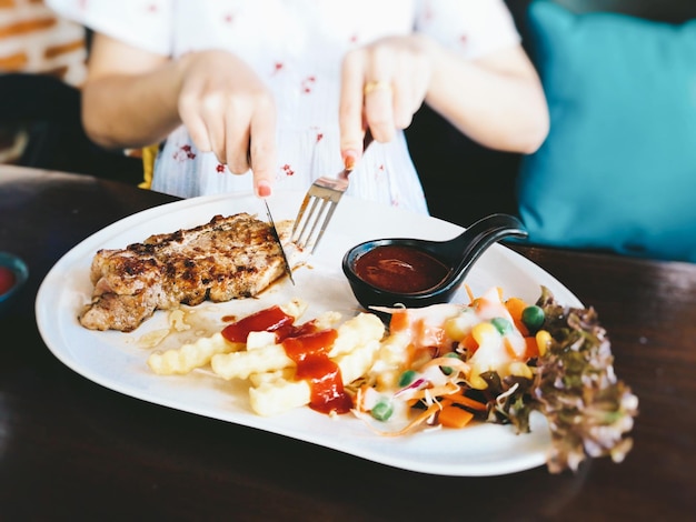 Zdjęcie Środkowa sekcja kobiety jedzącej w restauracji