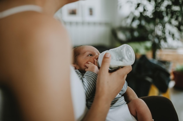 Zdjęcie Środkowa sekcja kobiety karmiącej mlekiem nowo narodzonego syna w domu