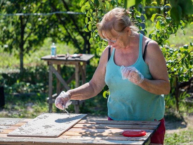 Zdjęcie Środkowa sekcja kobiety trzymającej stół na podwórku