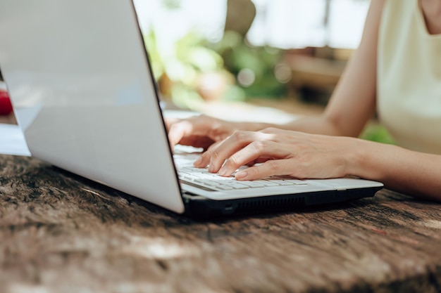 Środkowa sekcja kobiety używającej laptopa na stole