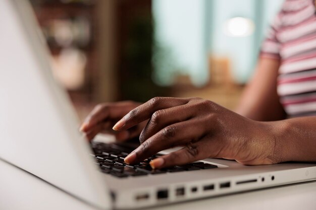 Środkowa sekcja kobiety używającej laptopa przy stole