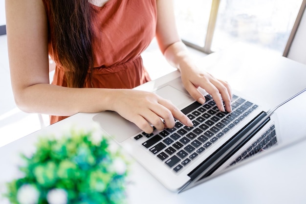 Środkowa sekcja kobiety używającej laptopa