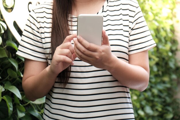 Zdjęcie Środkowa sekcja kobiety używającej telefonu komórkowego