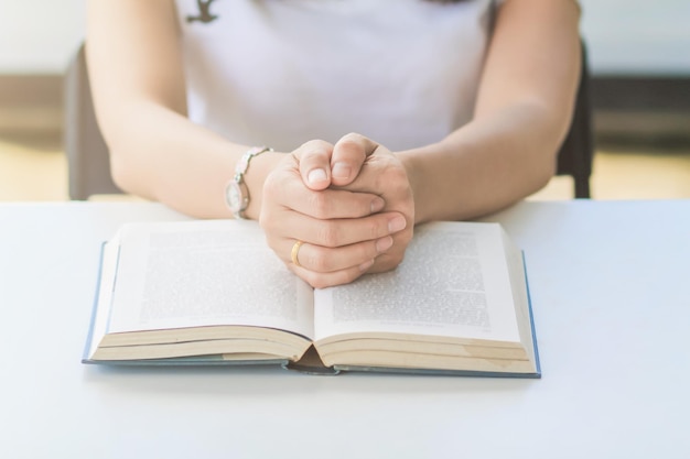 Środkowa sekcja kobiety z książką siedzącej przy stole