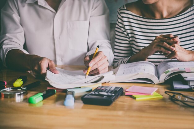 Zdjęcie Środkowa sekcja mężczyzny i kobiety studiującej na stole