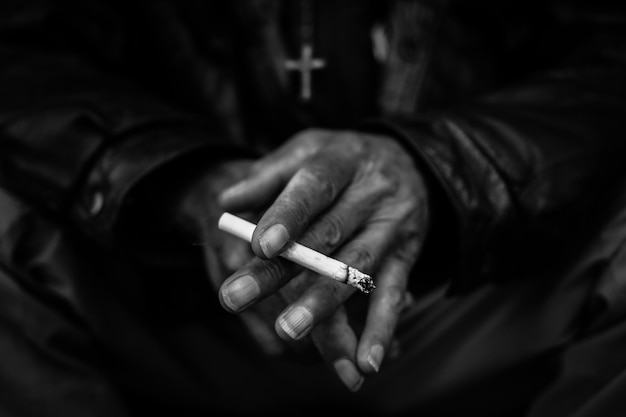 Środkowa sekcja mężczyzny trzymającego papierosa