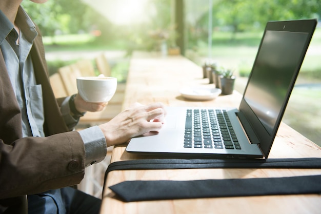 Środkowa sekcja mężczyzny używającego laptopa na stole