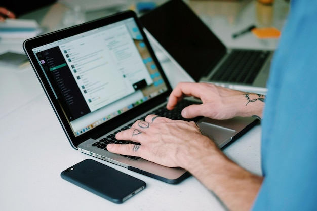 Zdjęcie Środkowa sekcja mężczyzny używającego laptopa na stole