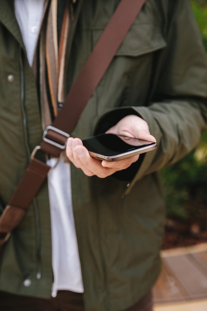 Zdjęcie Środkowa sekcja mężczyzny używającego telefonu komórkowego