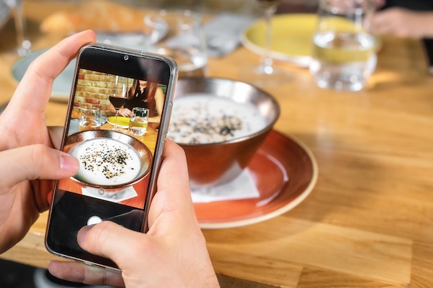 Zdjęcie Środkowa sekcja osoby fotografującej ze smartfonem na stole